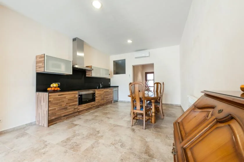 Cocina y comedor con gabinetes de madera y una mesa de comedor.