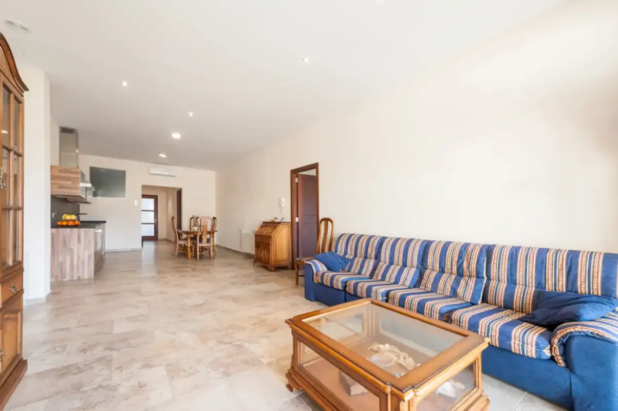 Una sala de estar con asientos azules a rayas y una mesa de centro de madera.