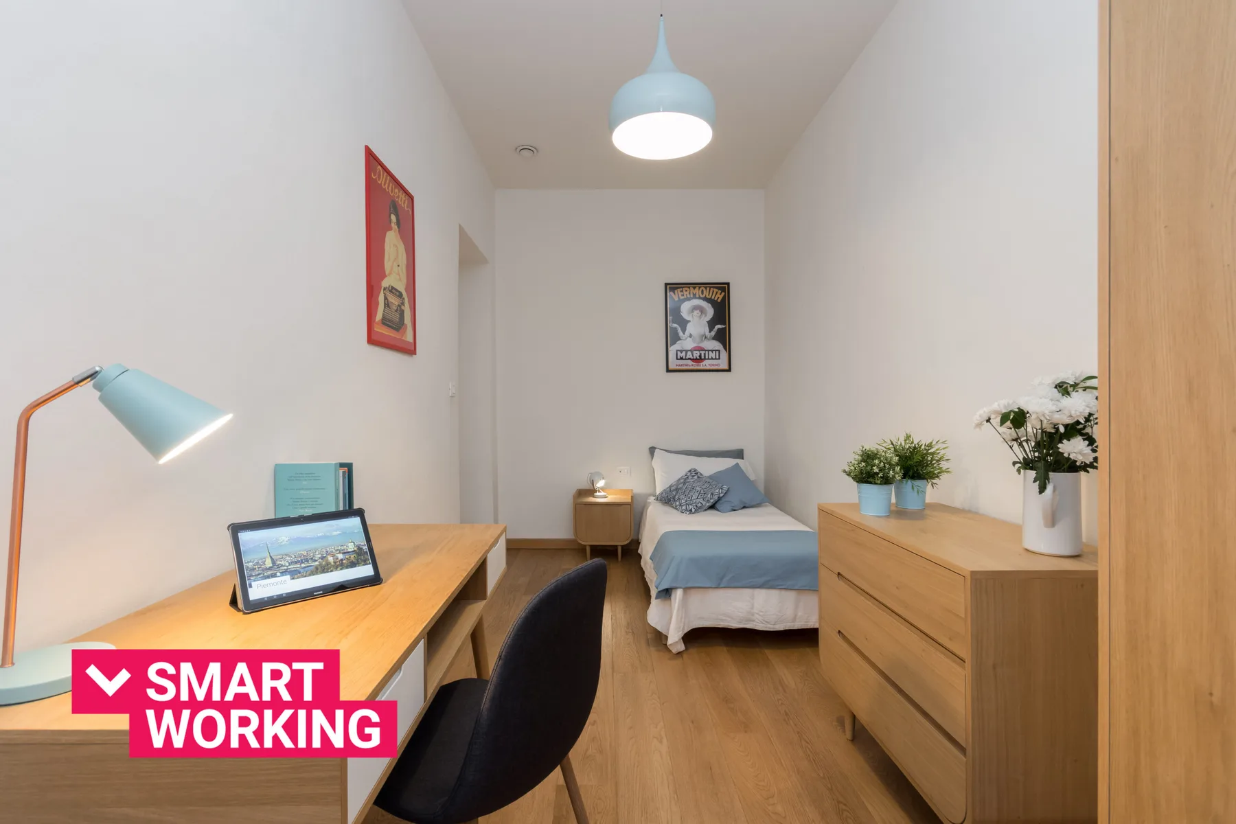 Un dormitorio con cama, escritorio y cómoda de madera.