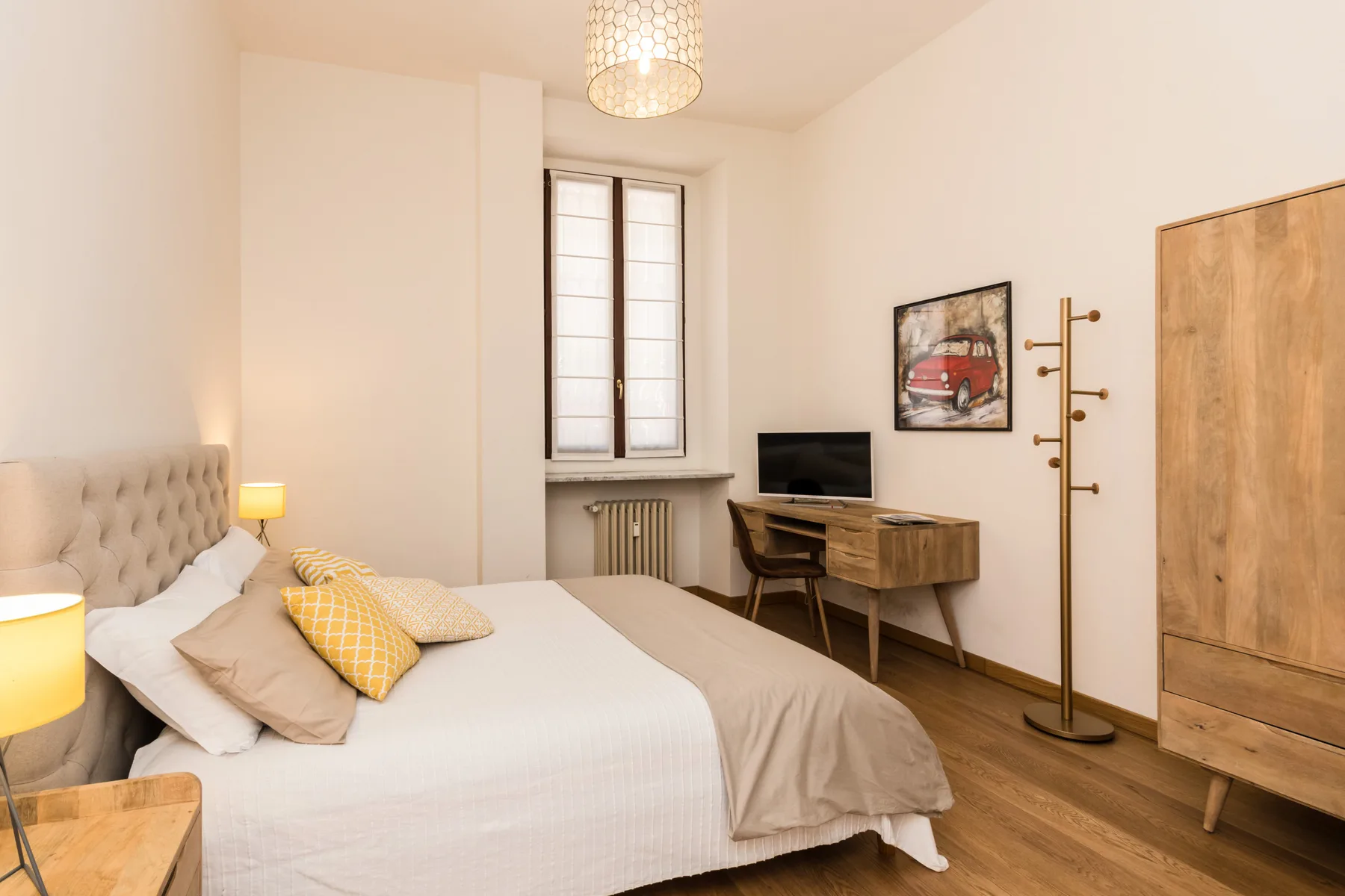 Un dormitorio con cama, escritorio y ventana.