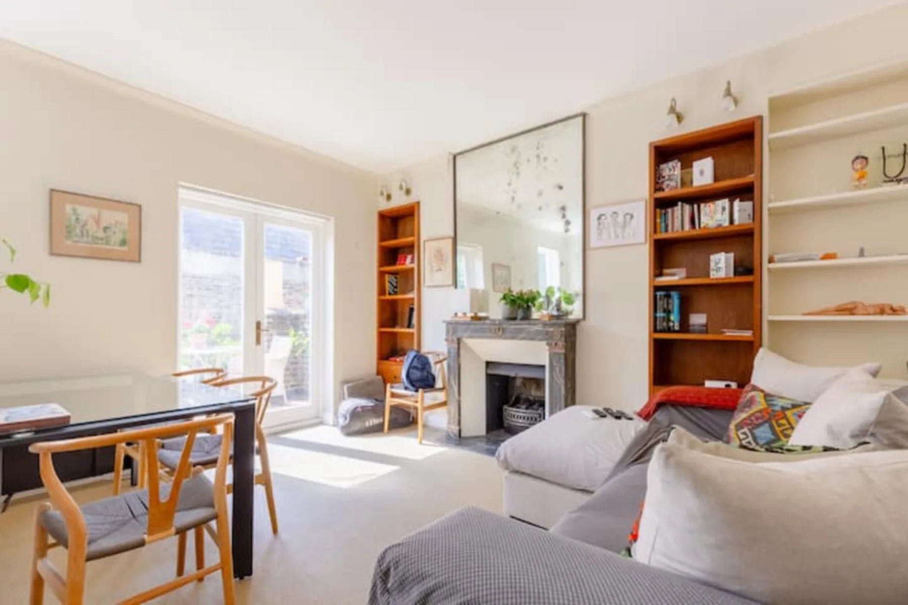 A bright living room with a fireplace, seating, and a dining table.