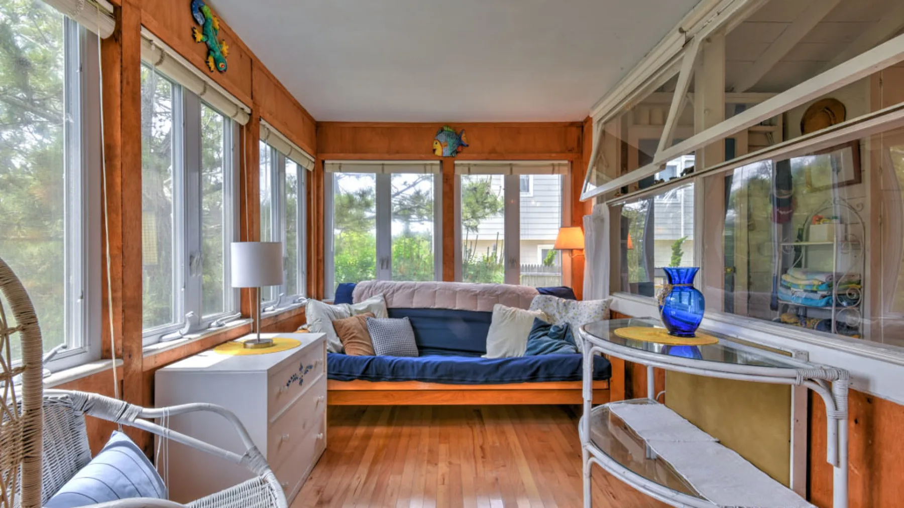 A bright living room has a blue sofa beside large windows.