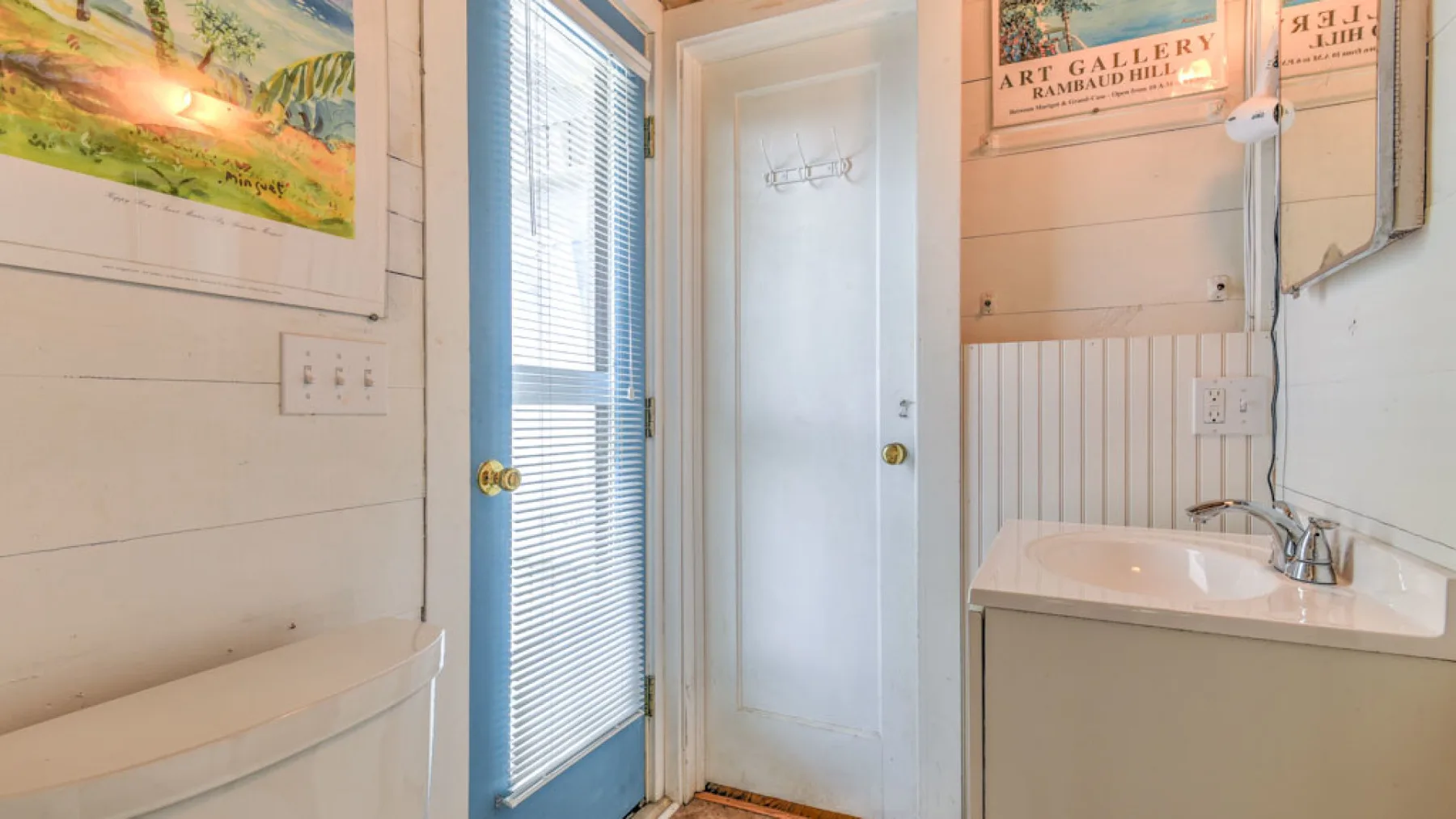 A bathroom with a sink, mirror, and shower.