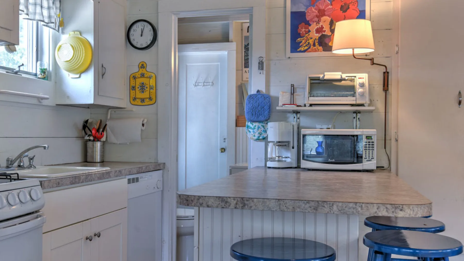 A bright kitchen with a central counter and small appliances.