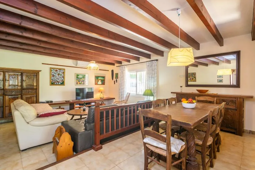 Comedor con una mesa de madera junto a una sala de estar con asientos.