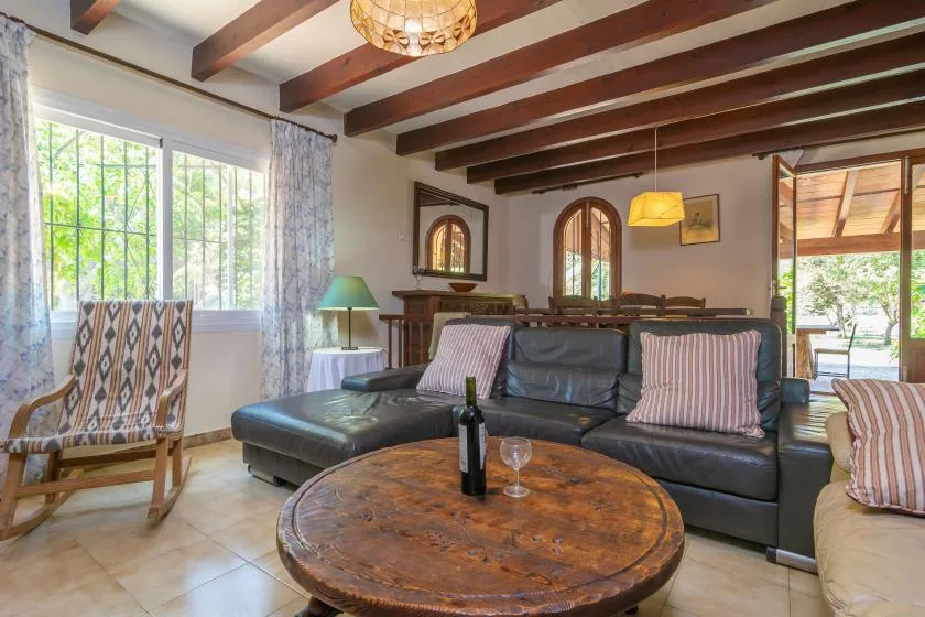 Una sala de estar con un sofá seccional oscuro y una mesa de centro redonda.