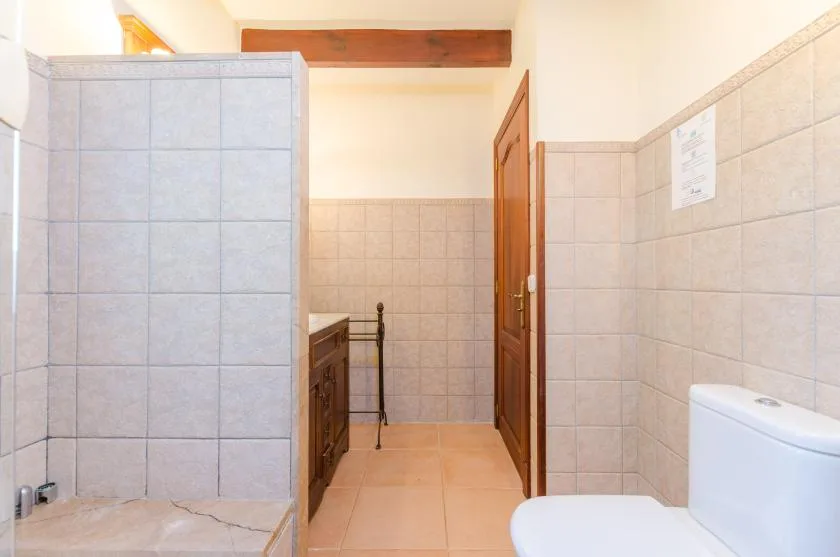 Un baño alicatado con zona de ducha e inodoro.