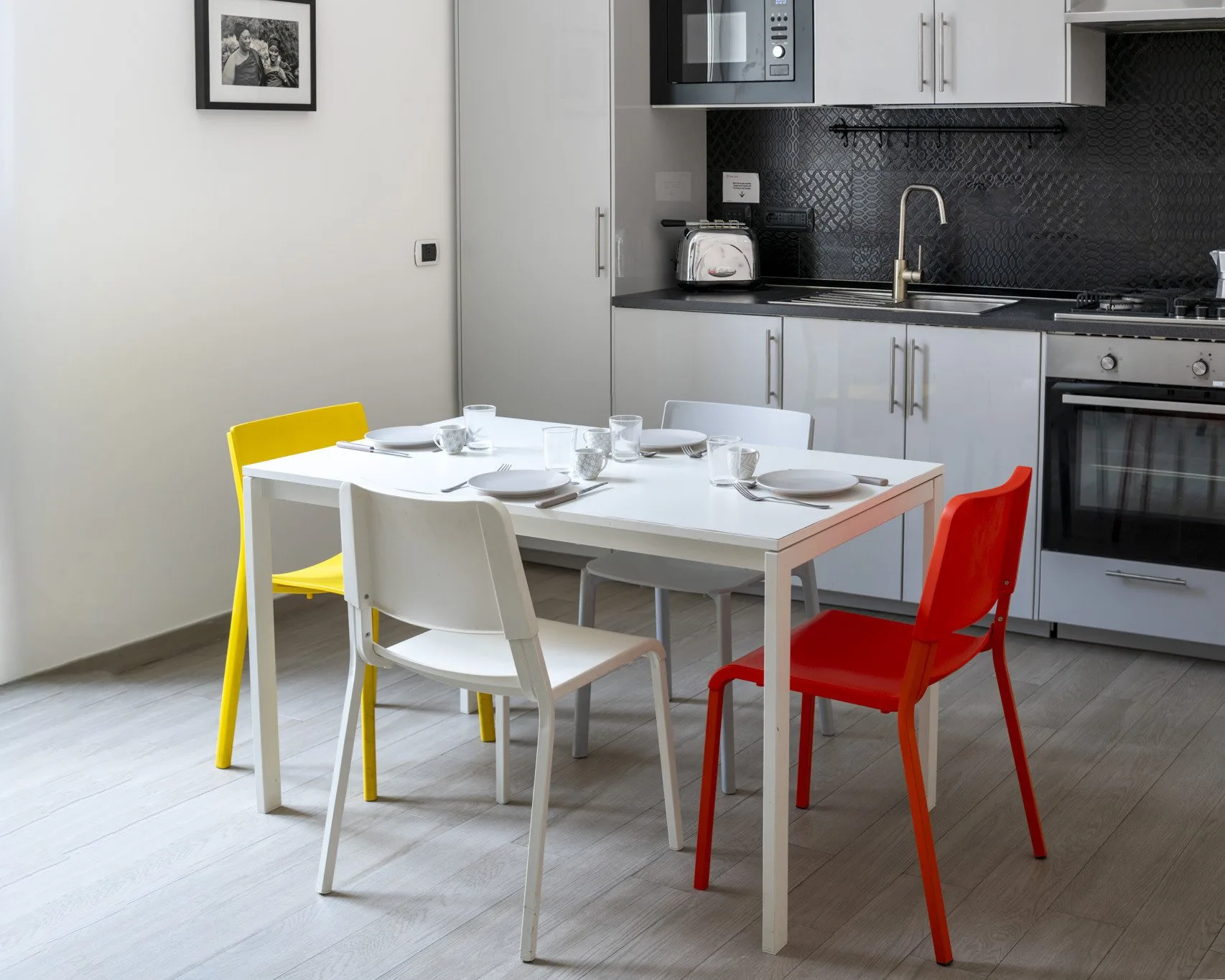 A dining area with a set table beside a compact kitchen.