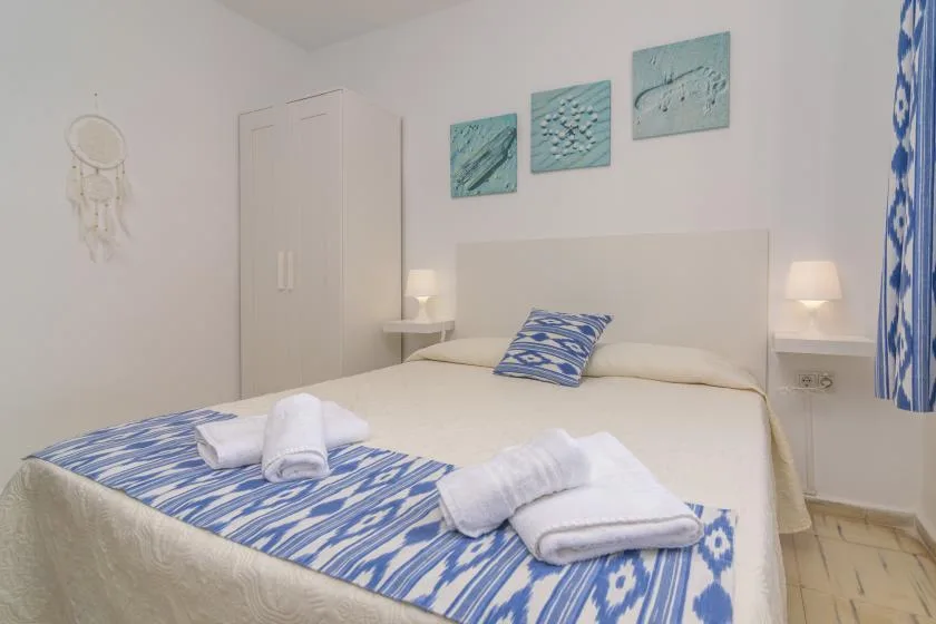 Un dormitorio con una cama tendida y ropa de cama con estampado azul.