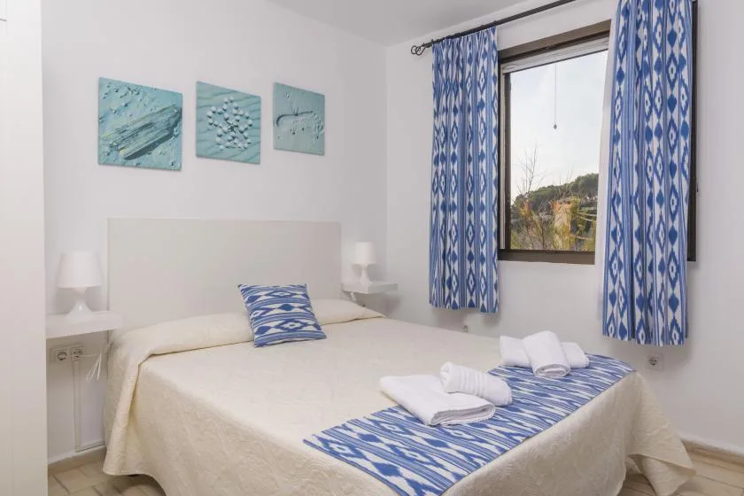 Un dormitorio con cama doble, cortinas estampadas azules y detalles decorativos a juego.