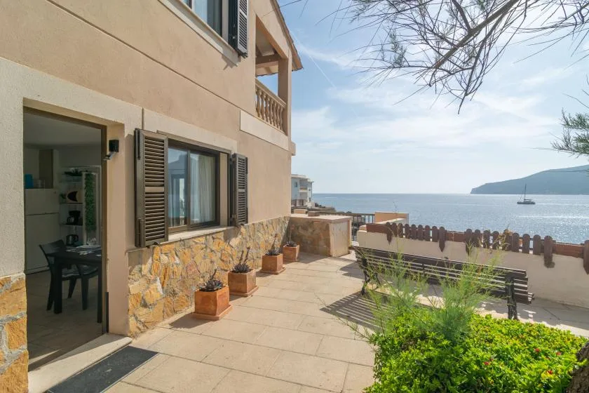 Un patio exterior embaldosado junto a una casa da al mar.