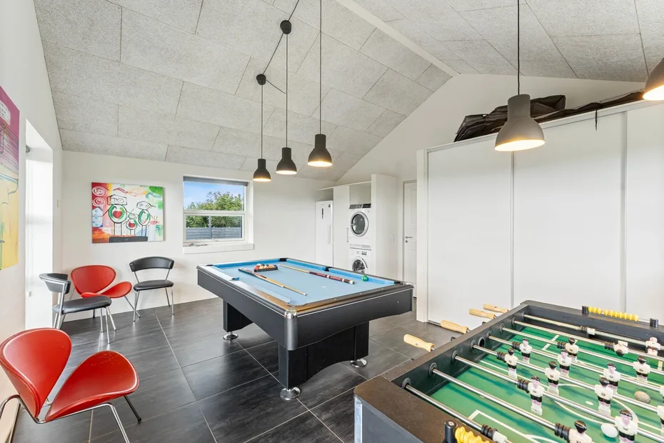Una sala de juegos con una mesa de billar y una de futbolín.