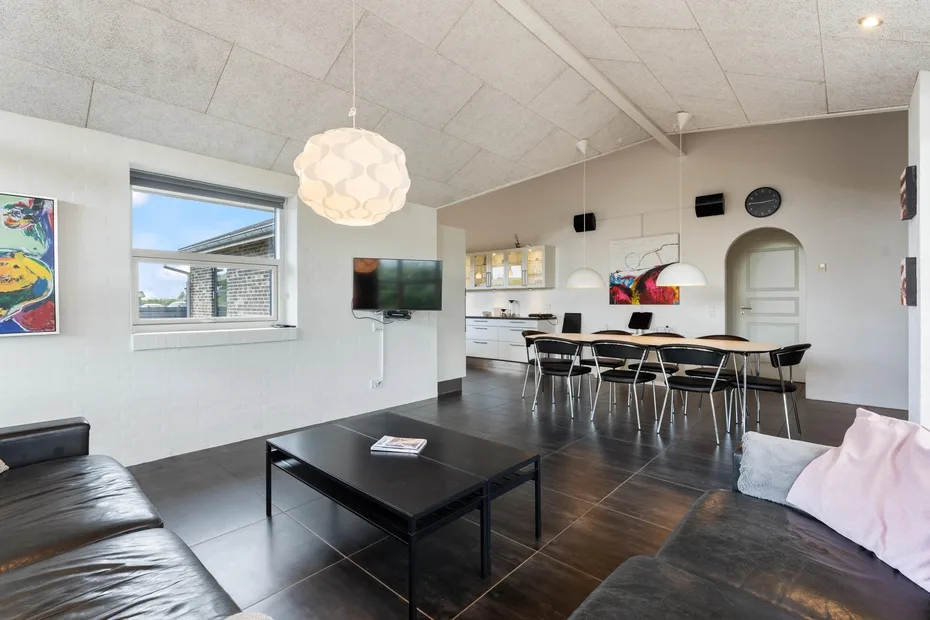 Una sala amplia con asientos oscuros, una mesa de centro y un comedor.