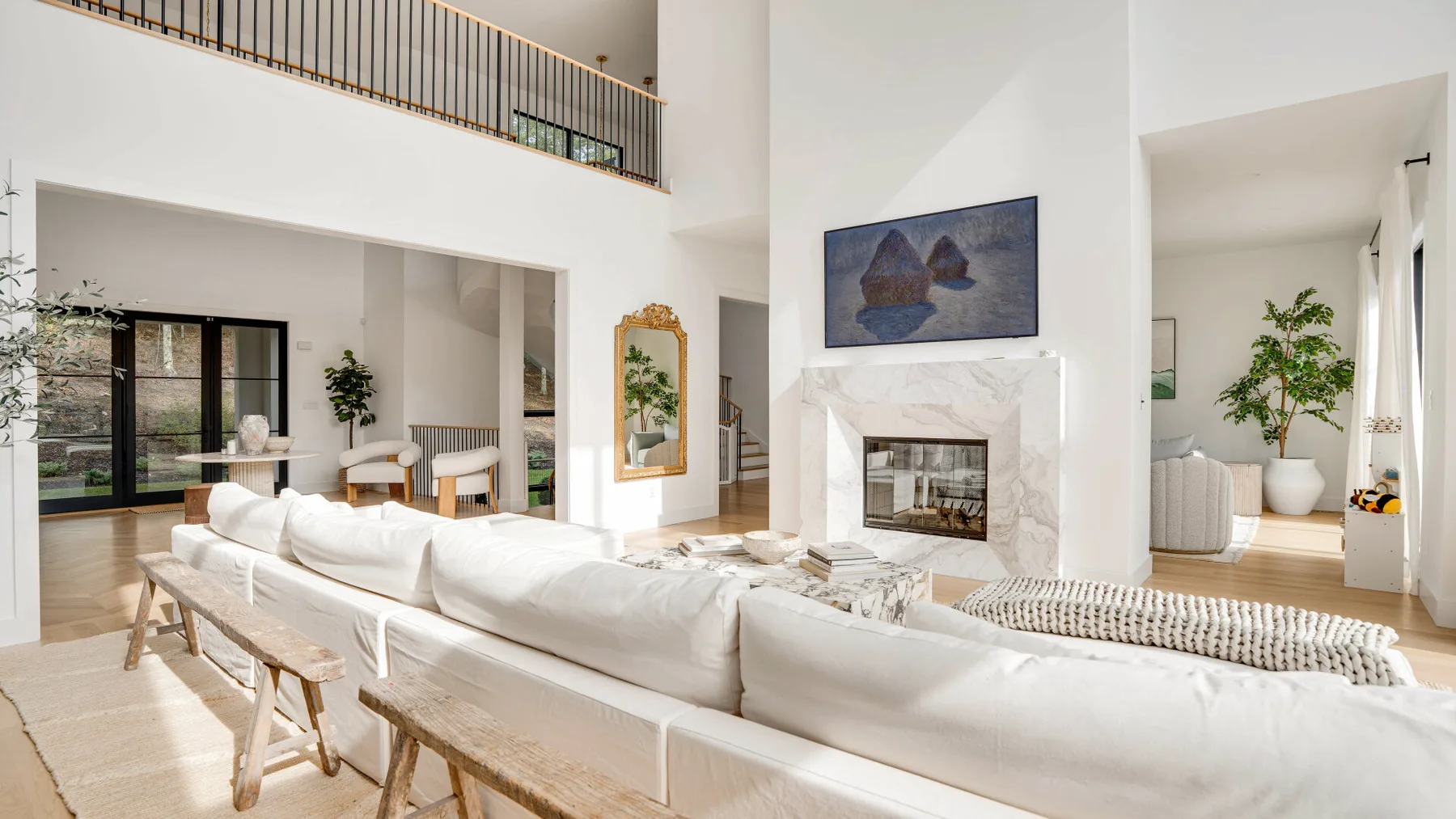 Una sala luminosa con asientos blancos dispuestos alrededor de una chimenea.