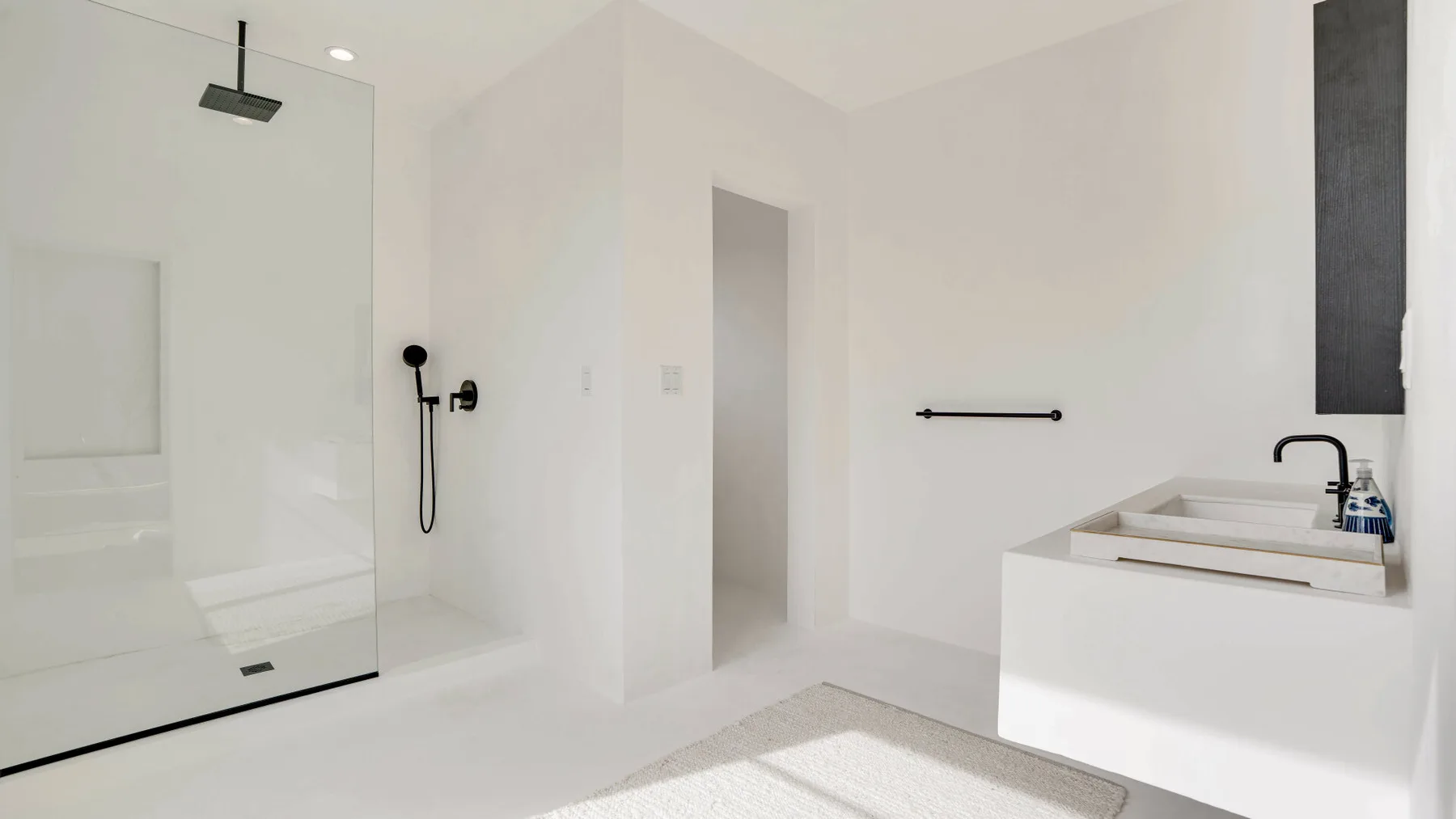 Un baño luminoso con una ducha de vidrio y una bañera exenta.