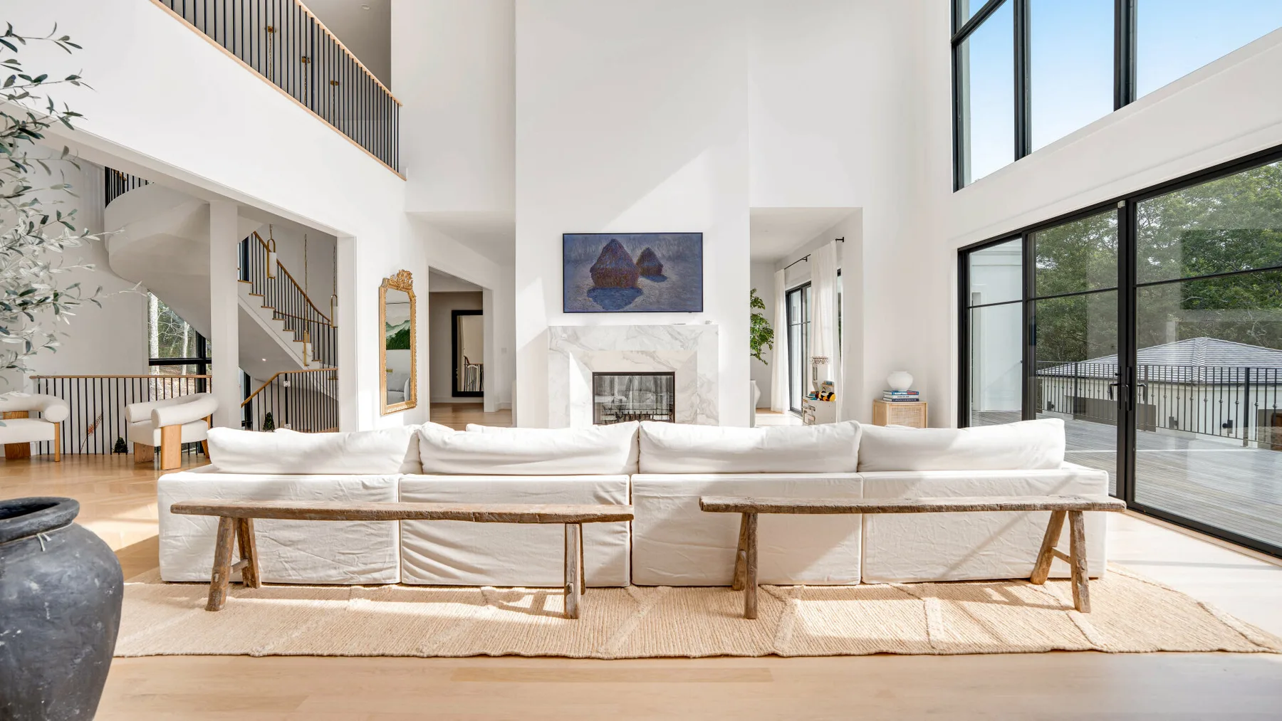 Una sala luminosa con asientos blancos y ventanales grandes.