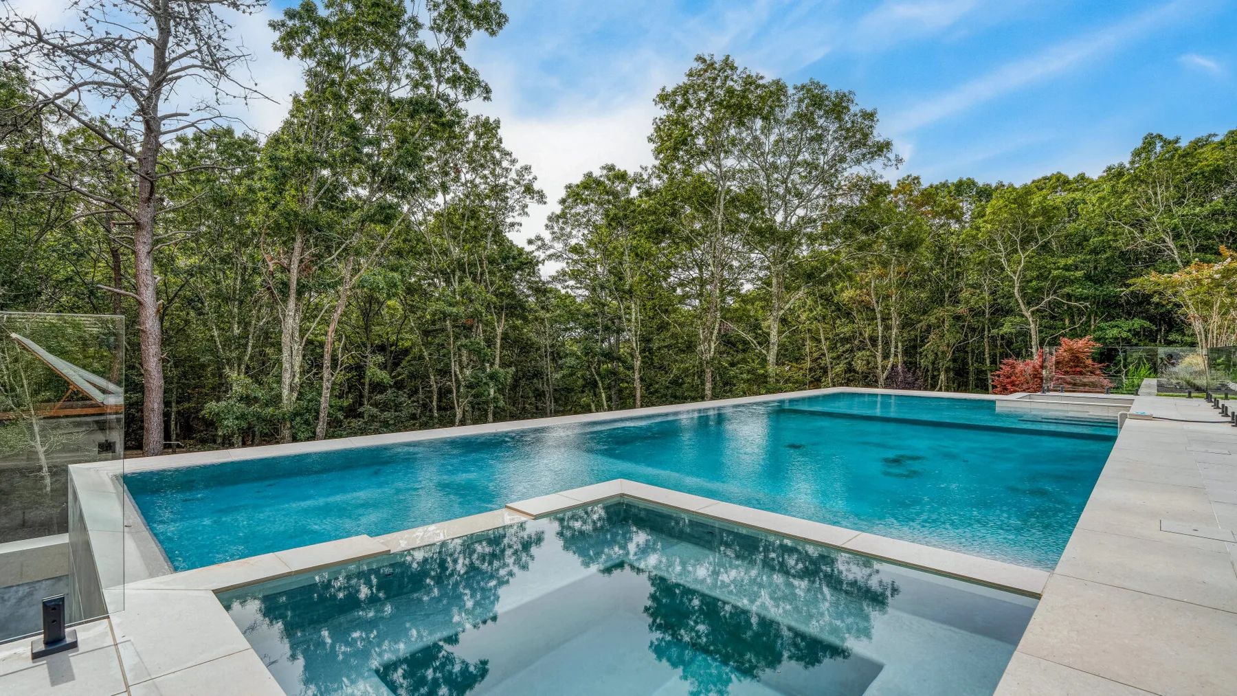 Una piscina al aire libre rodeada de árboles.