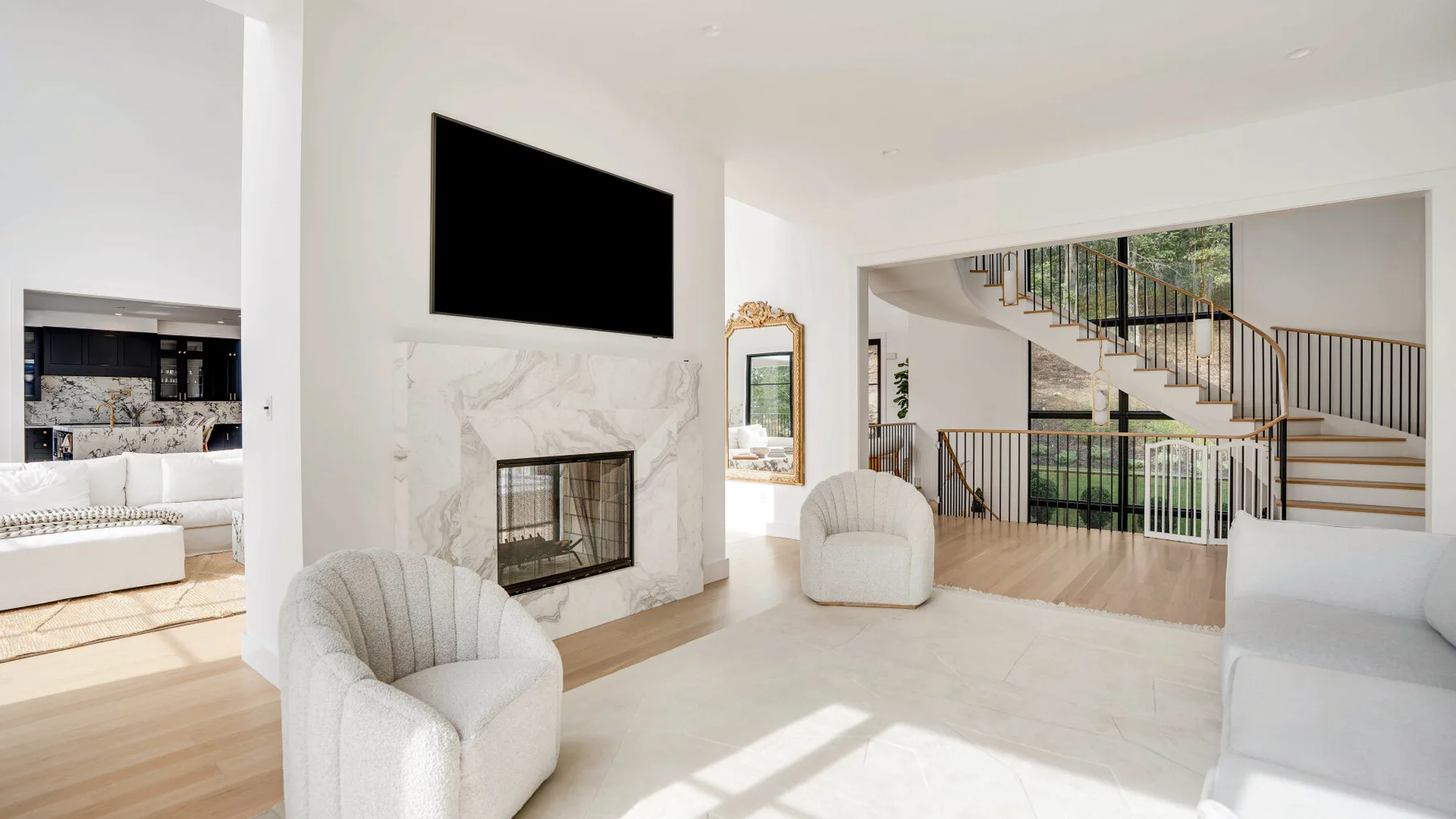 Una sala luminosa con asientos blancos y una chimenea de mármol.