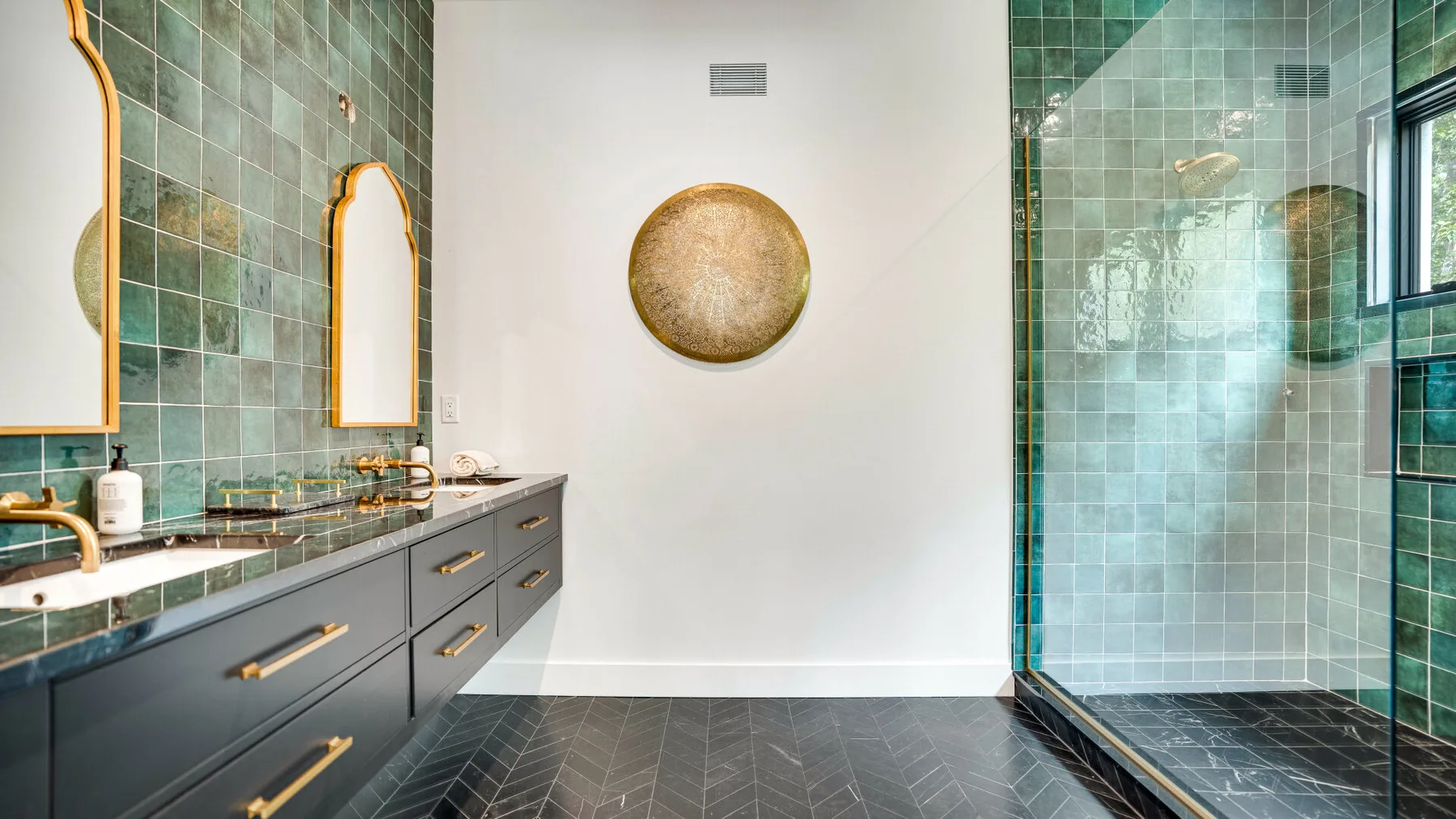 Un lavabo de baño con espejos y una zona de ducha acristalada.