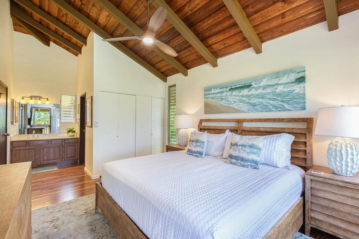 Un dormitorio con una cama grande bajo un techo con vigas de madera.