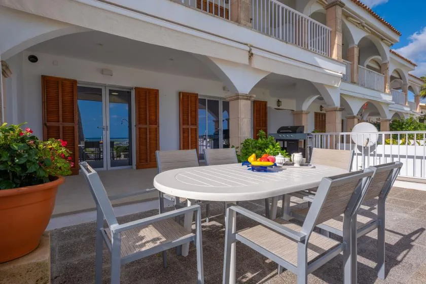 A sunny outdoor dining area with a table and chairs beside the building.