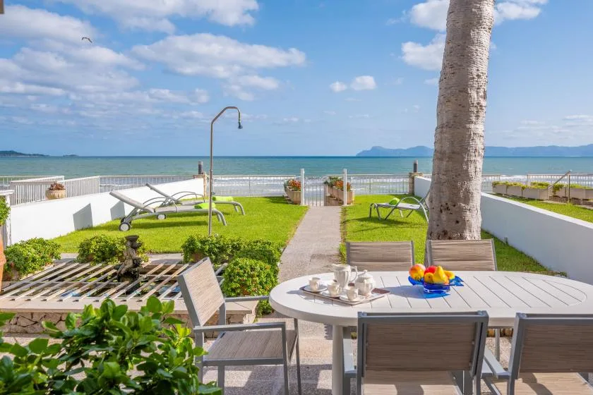 A seaside patio with outdoor seating and a view of the ocean.