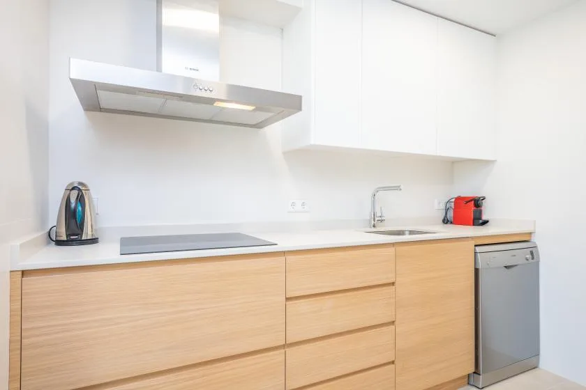 A bright kitchen with light wood cabinets and a countertop.