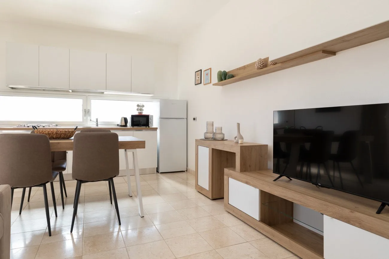 Una luminosa sala-comedor con televisor y mesa de comedor.