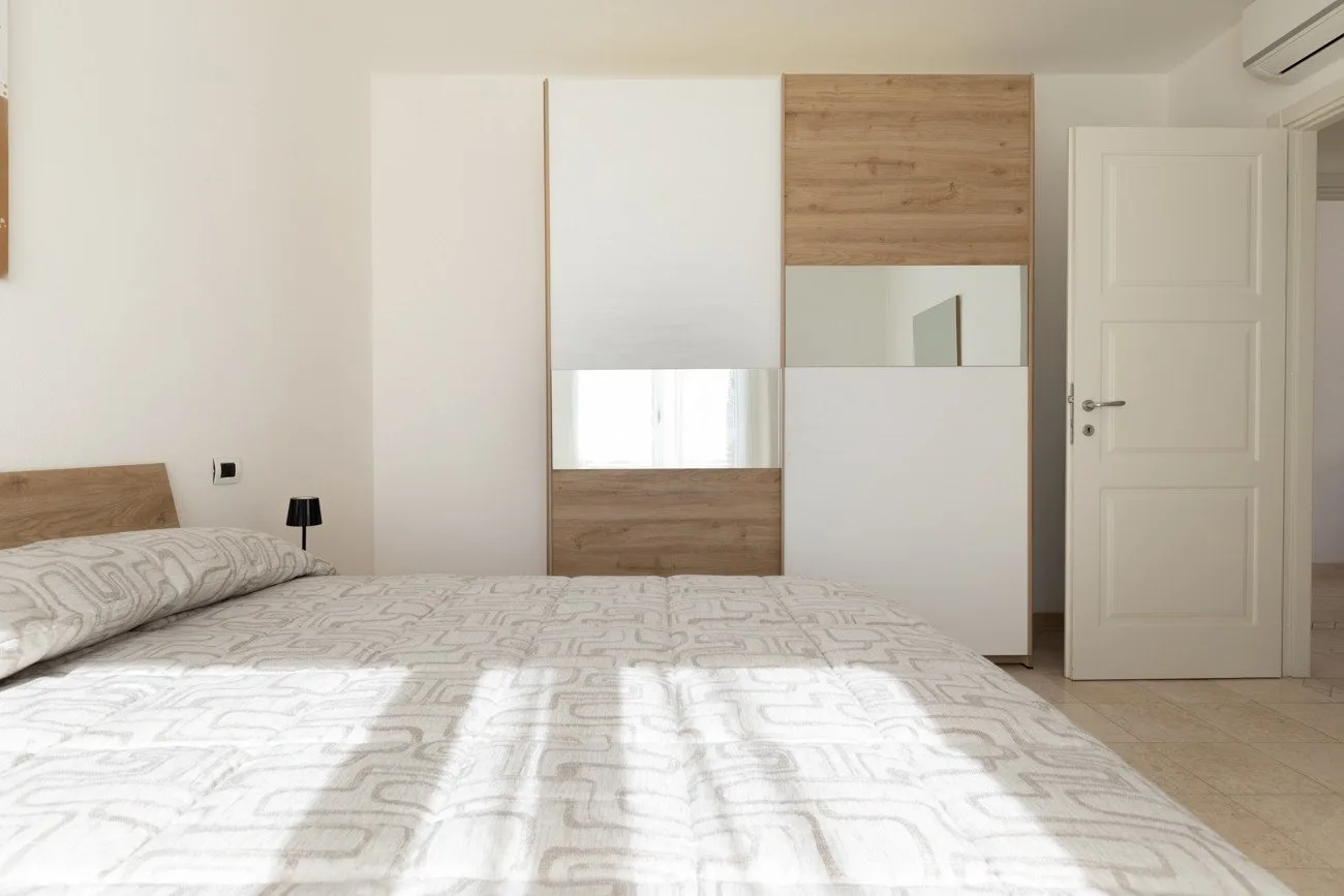 Un dormitorio con una cama y almacenamiento empotrado en la pared del fondo.