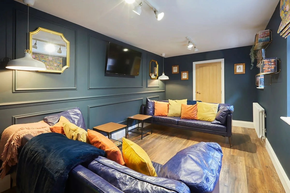 A dark-paneled lounge with seating around a low coffee table.