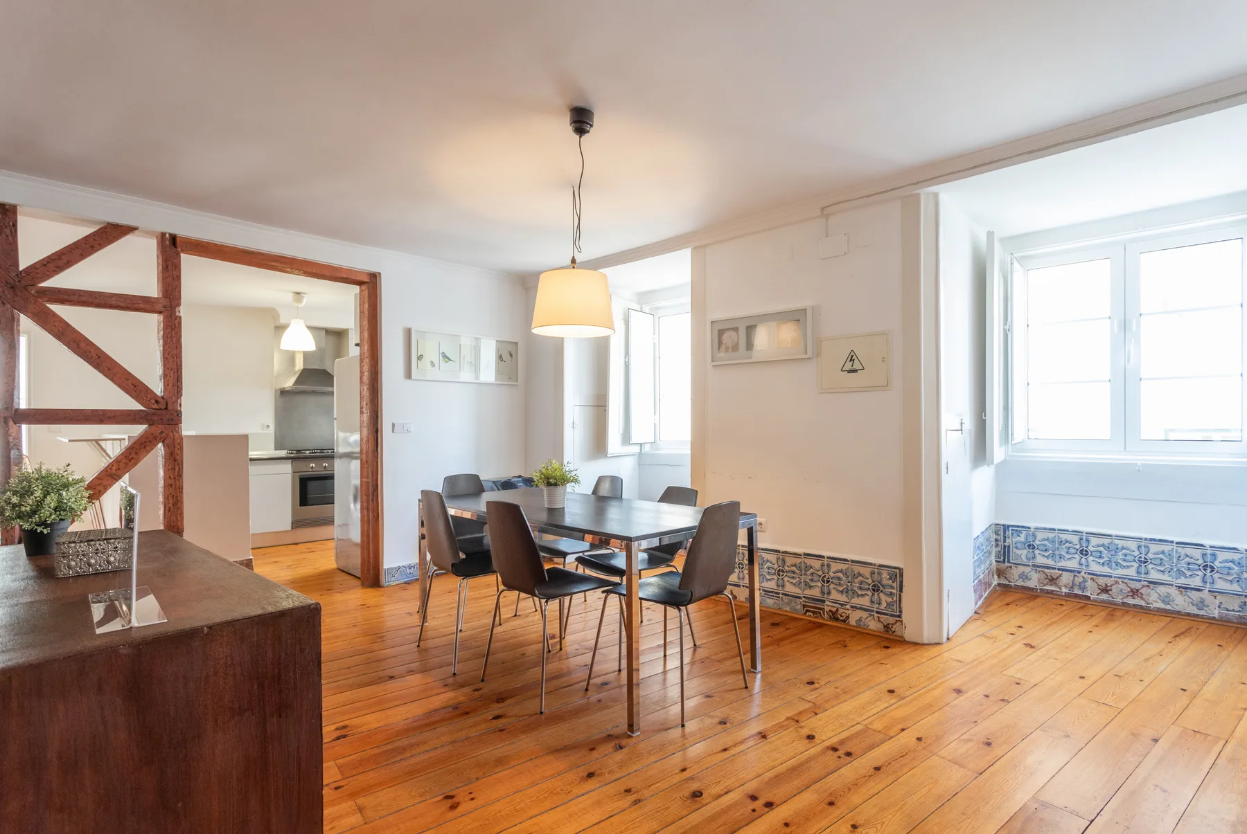 Comedor con una mesa y asientos junto a una cocina abierta.