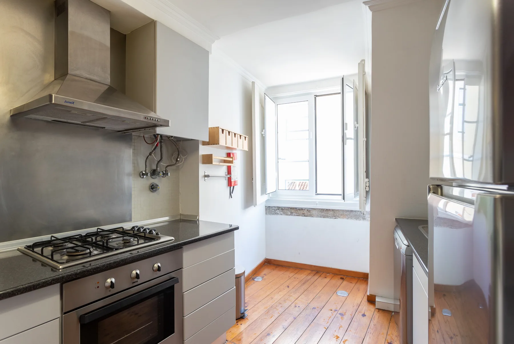 Una cocina compacta con una placa de gas y una ventana luminosa.