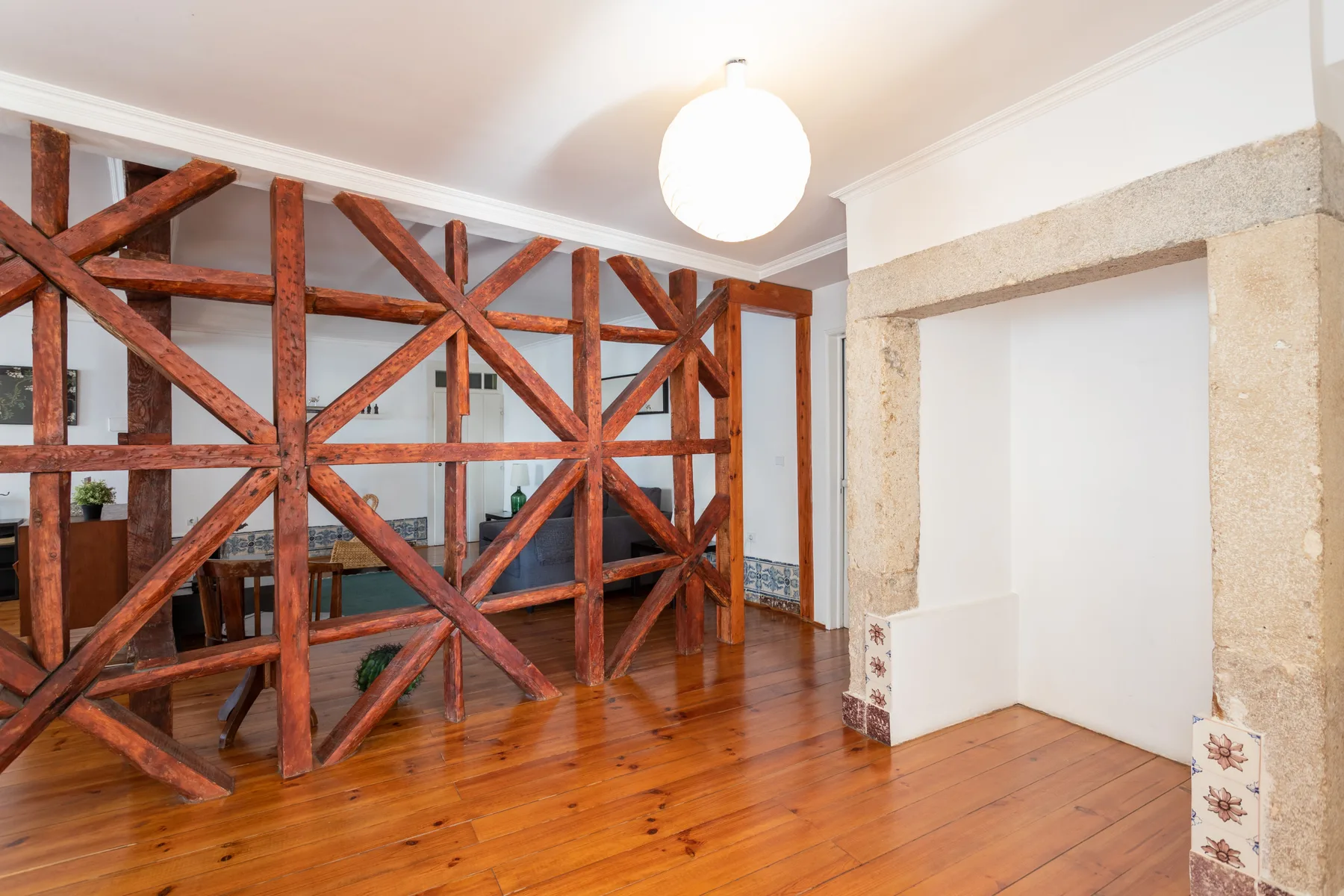 Una habitación luminosa con suelo de madera y vigas de madera a la vista.