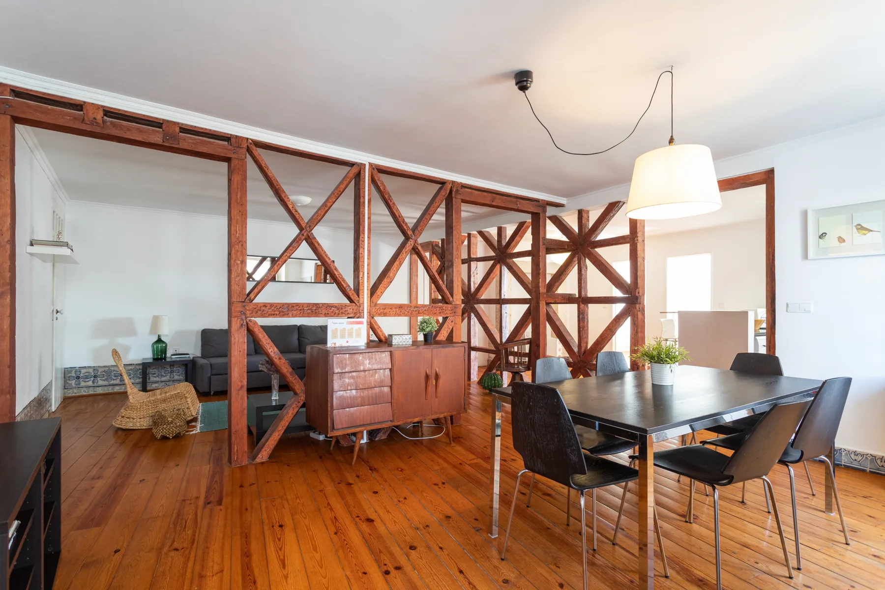Comedor con una mesa y sillas junto a vigas de madera a la vista.