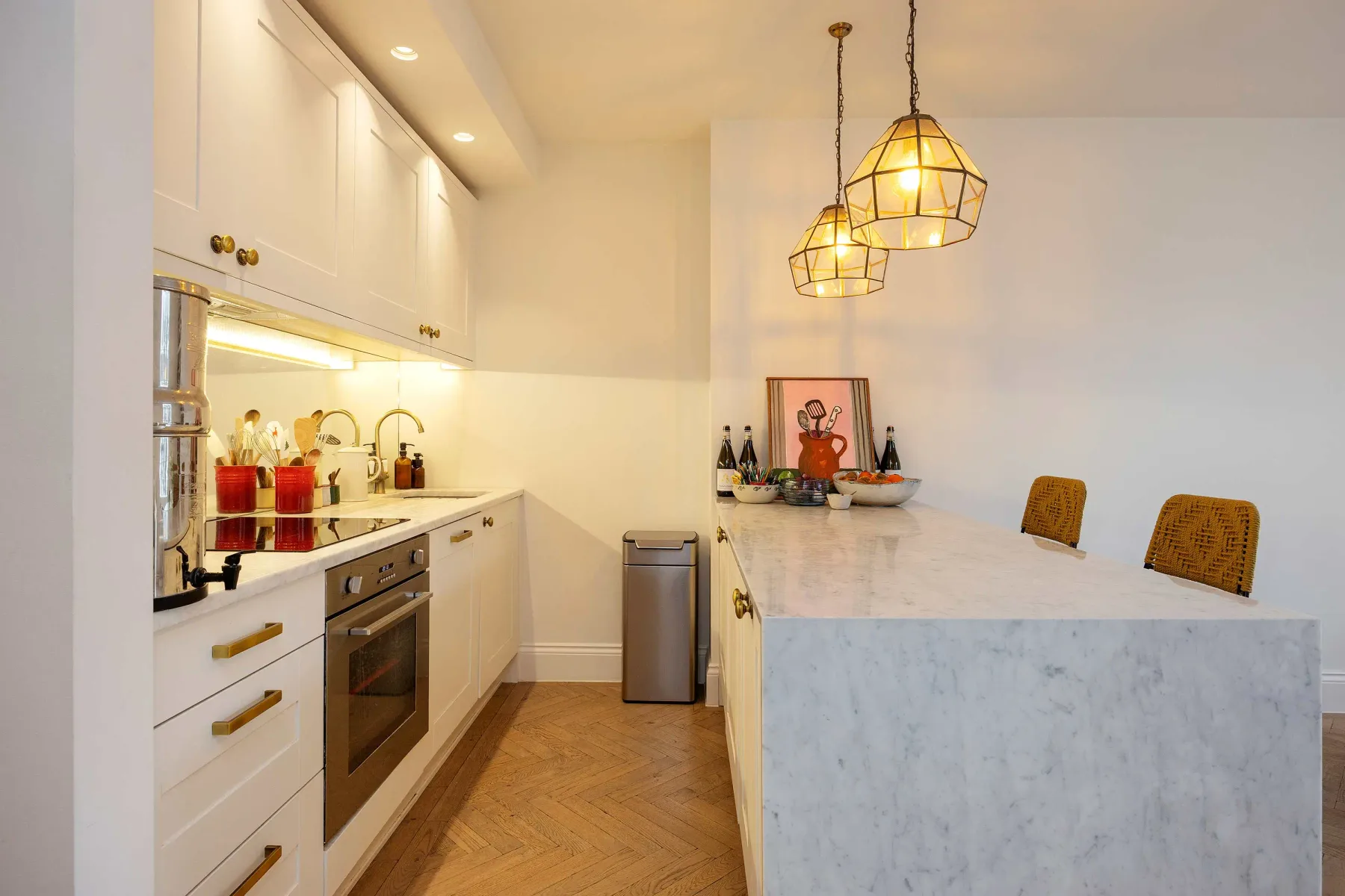 A bright kitchen with a long island and pendant lights.