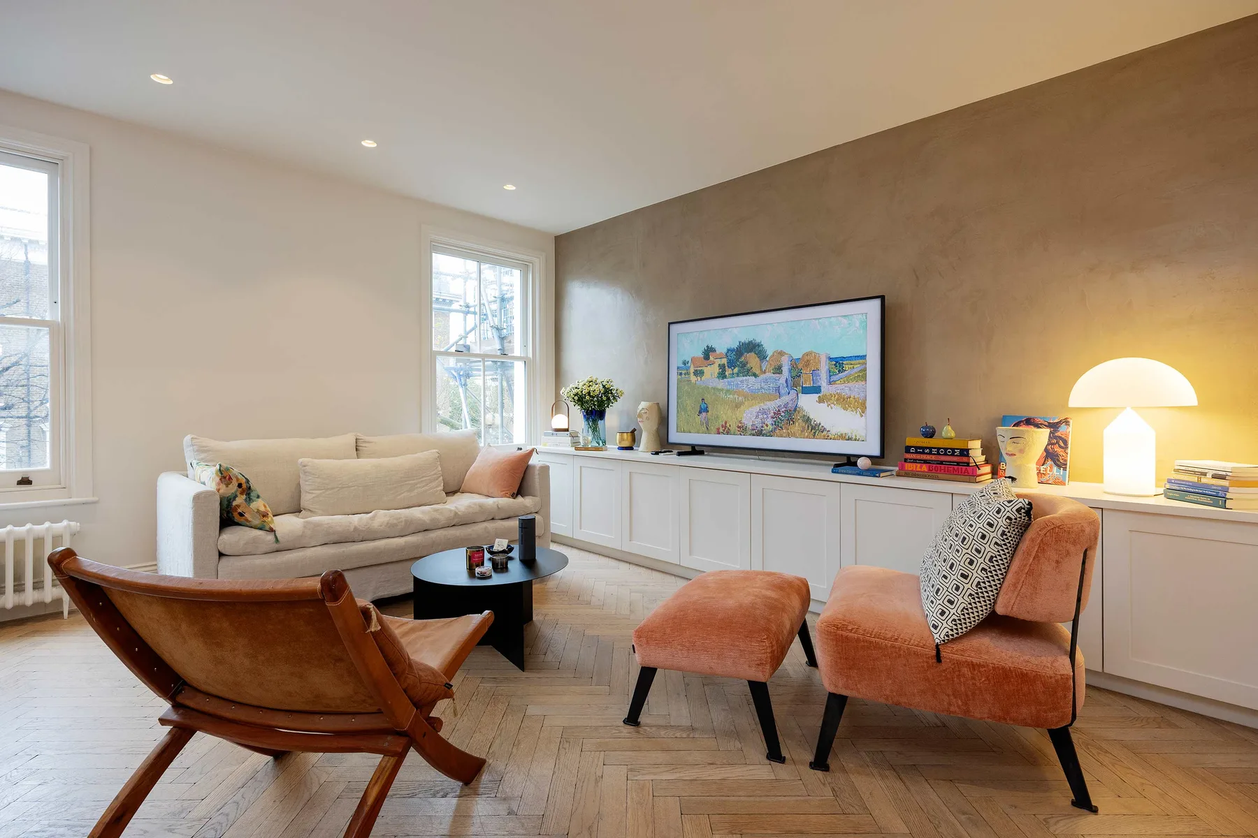 A bright living room with seating arranged around a television and low table.