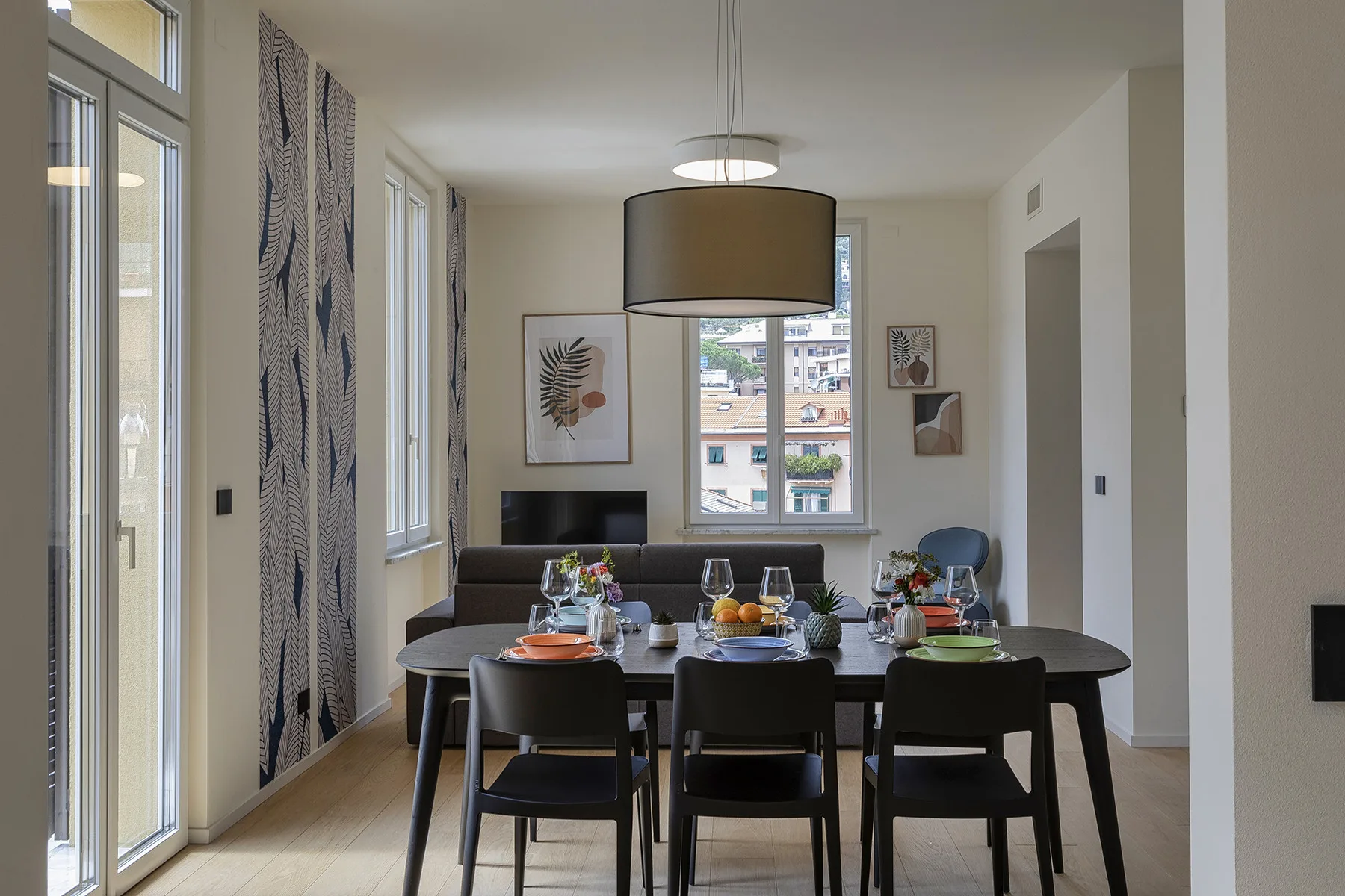 Un comedor con una mesa y sillas bajo una lámpara colgante.