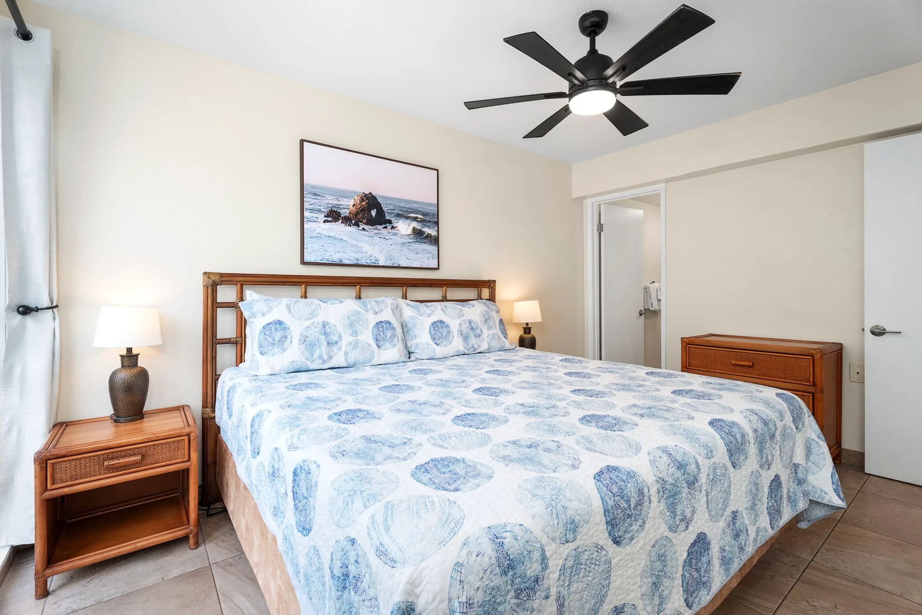 Un dormitorio con una cama vestida con ropa de cama estampada azul y blanca.