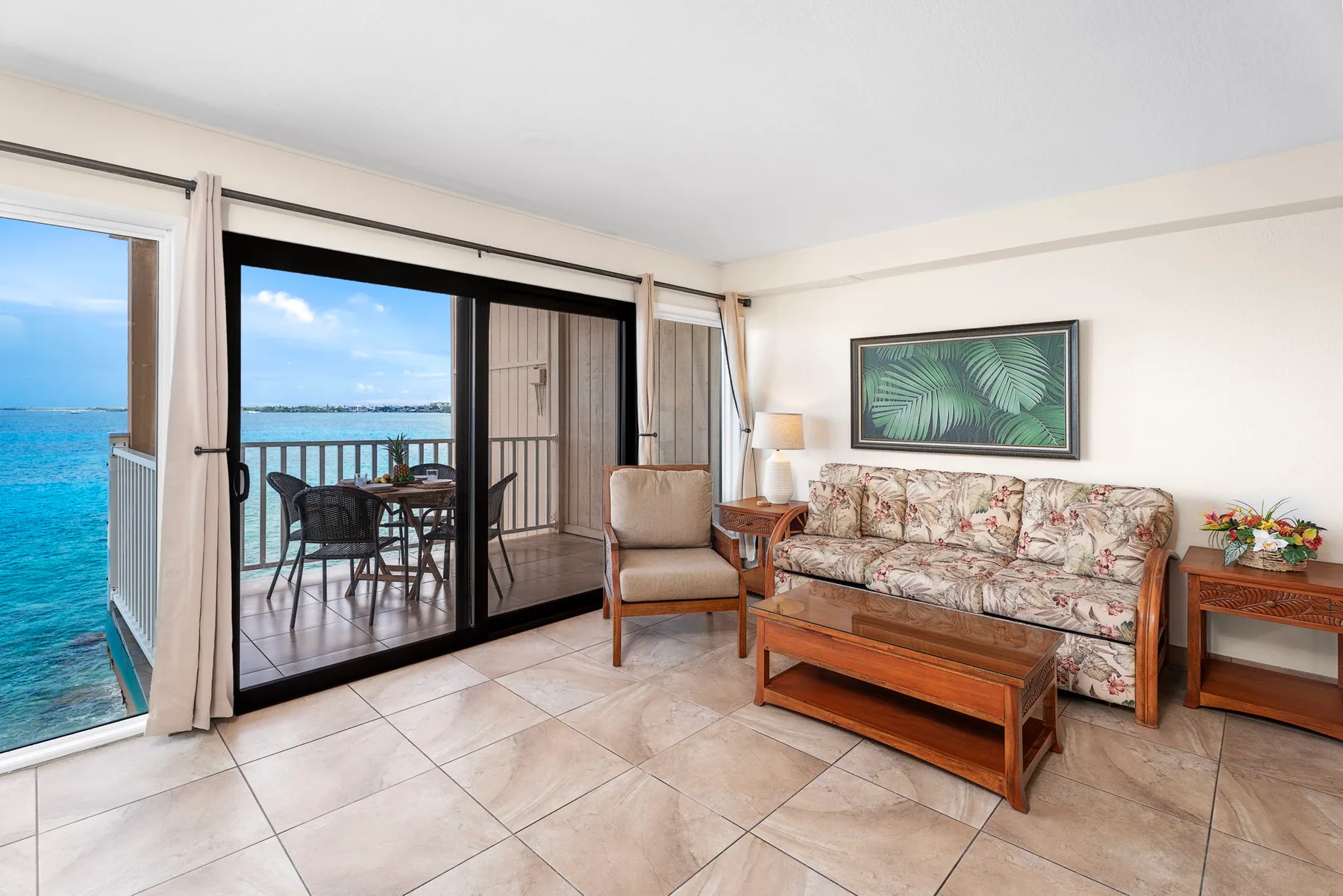 A living room with seating and a sliding glass door opening onto a balcony.