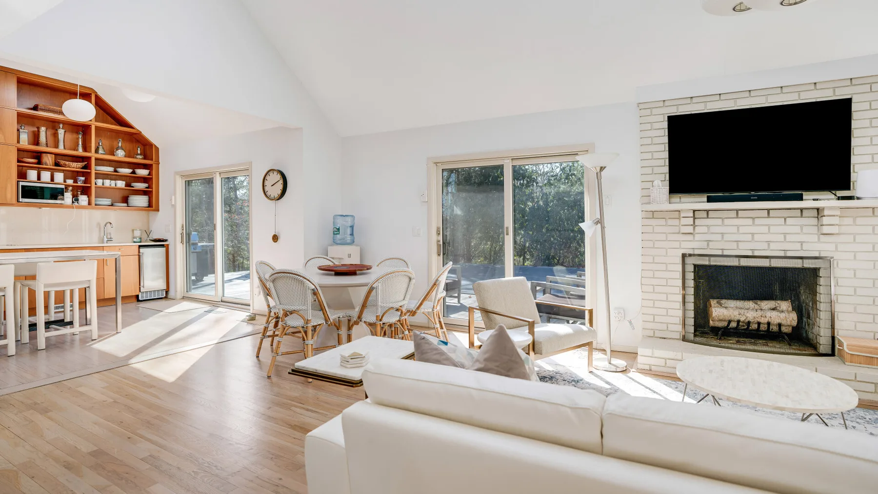 Una sala luminosa con asientos, chimenea y zona de comedor.