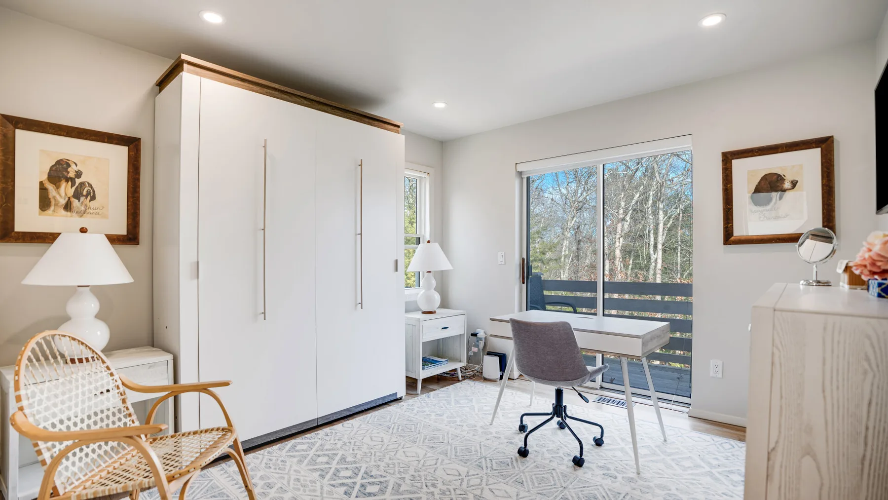 Un espacio de trabajo luminoso en un dormitorio, con escritorio, silla de oficina y una ventana amplia.