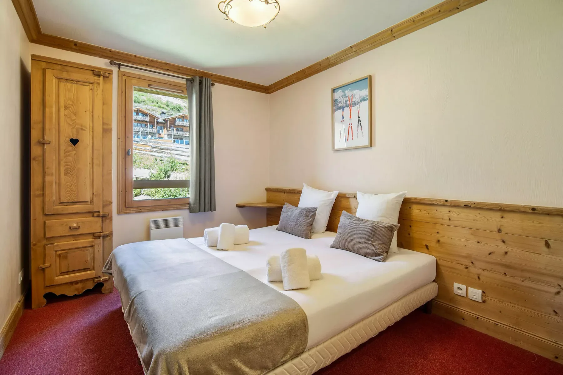 Un dormitorio con una cama, paneles de madera y una ventana.