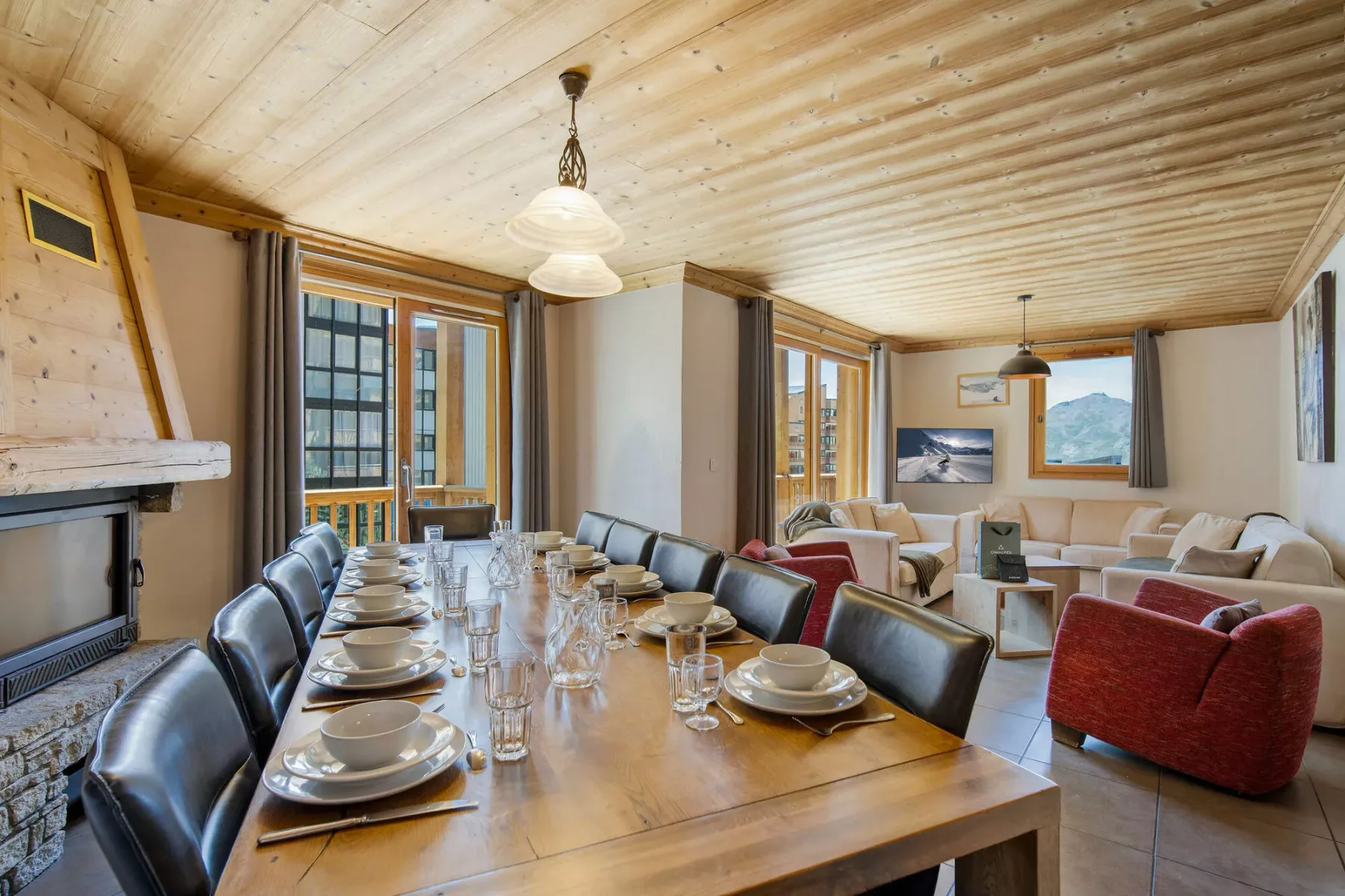 A wood-paneled dining and living room with a long table and seating.