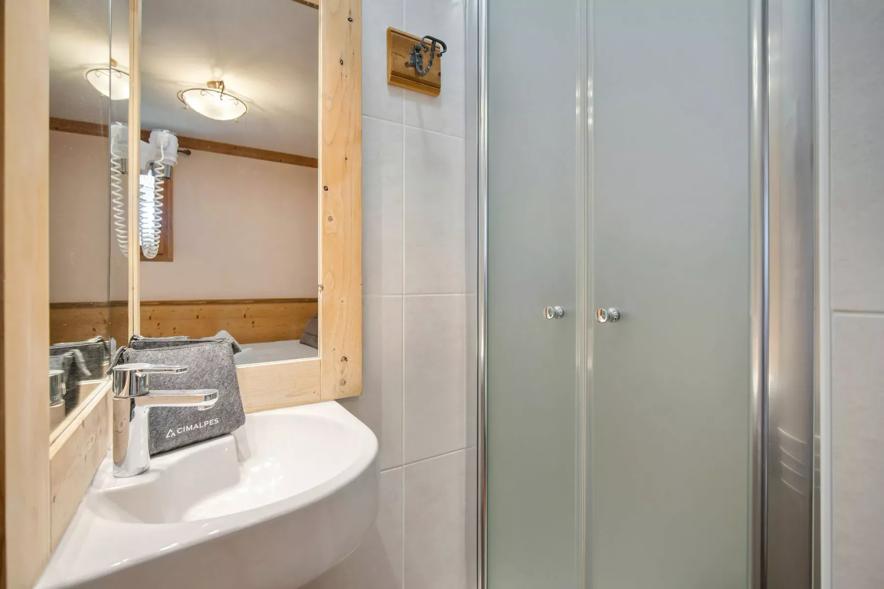 A bathroom sink and mirror beside a glass shower.