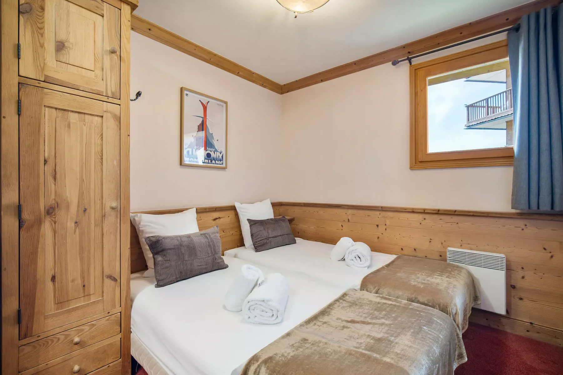 A bedroom with two beds, white linens, and wood-paneled walls.