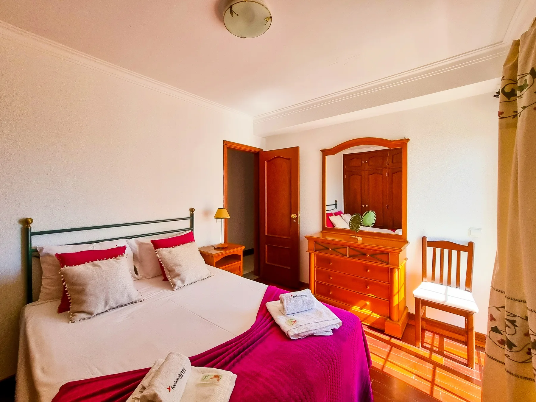Un dormitorio con una cama, una cómoda de madera y una silla.