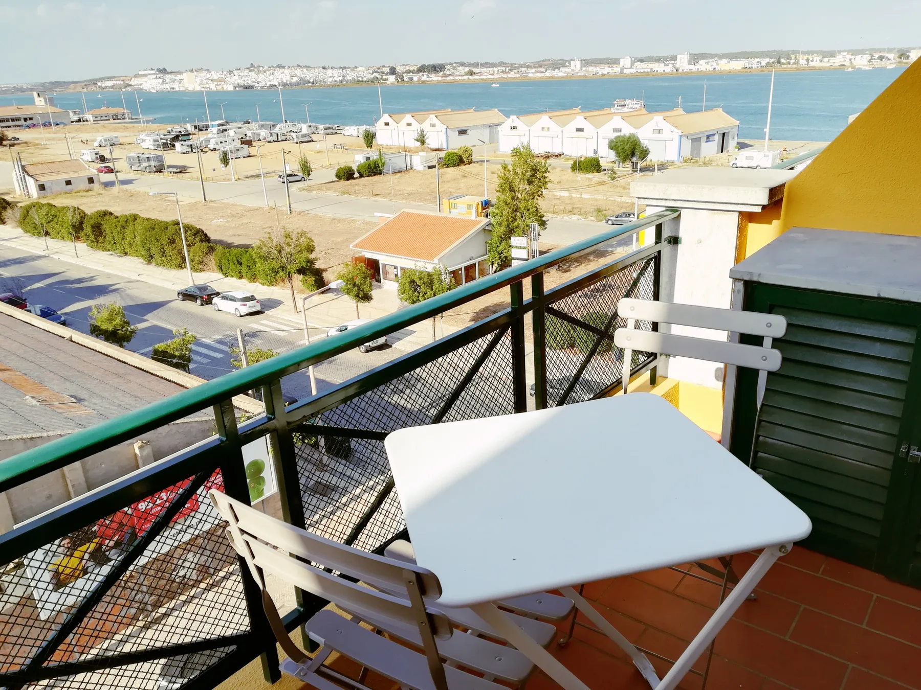 Una zona de estar en el balcón da a la costa y a edificios cercanos.