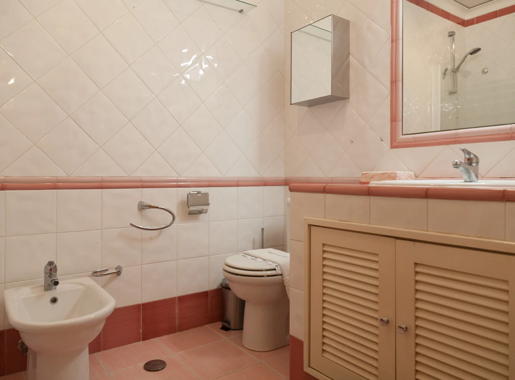 Un baño con azulejos, lavabo, inodoro y ducha.