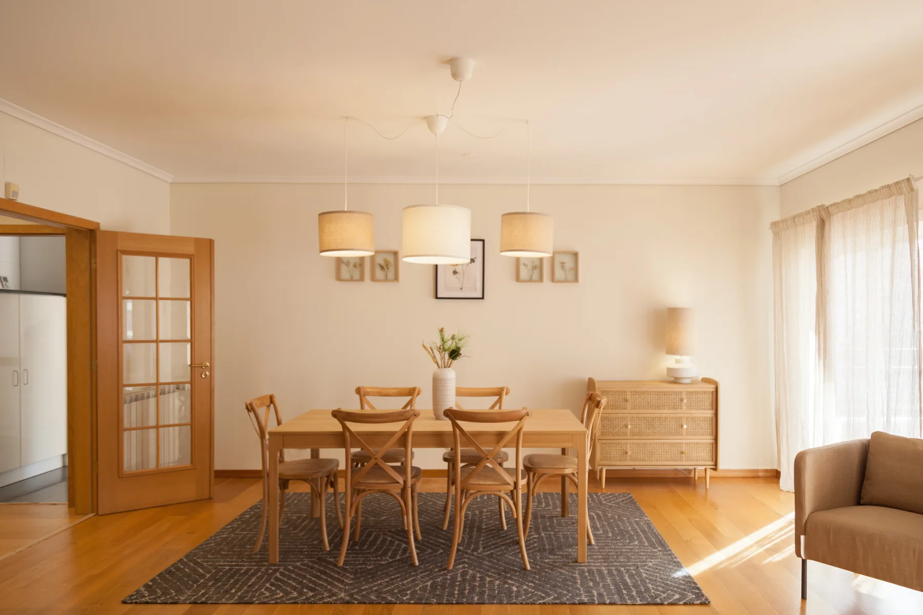 Comedor con una mesa de madera y sillas sobre una alfombra.