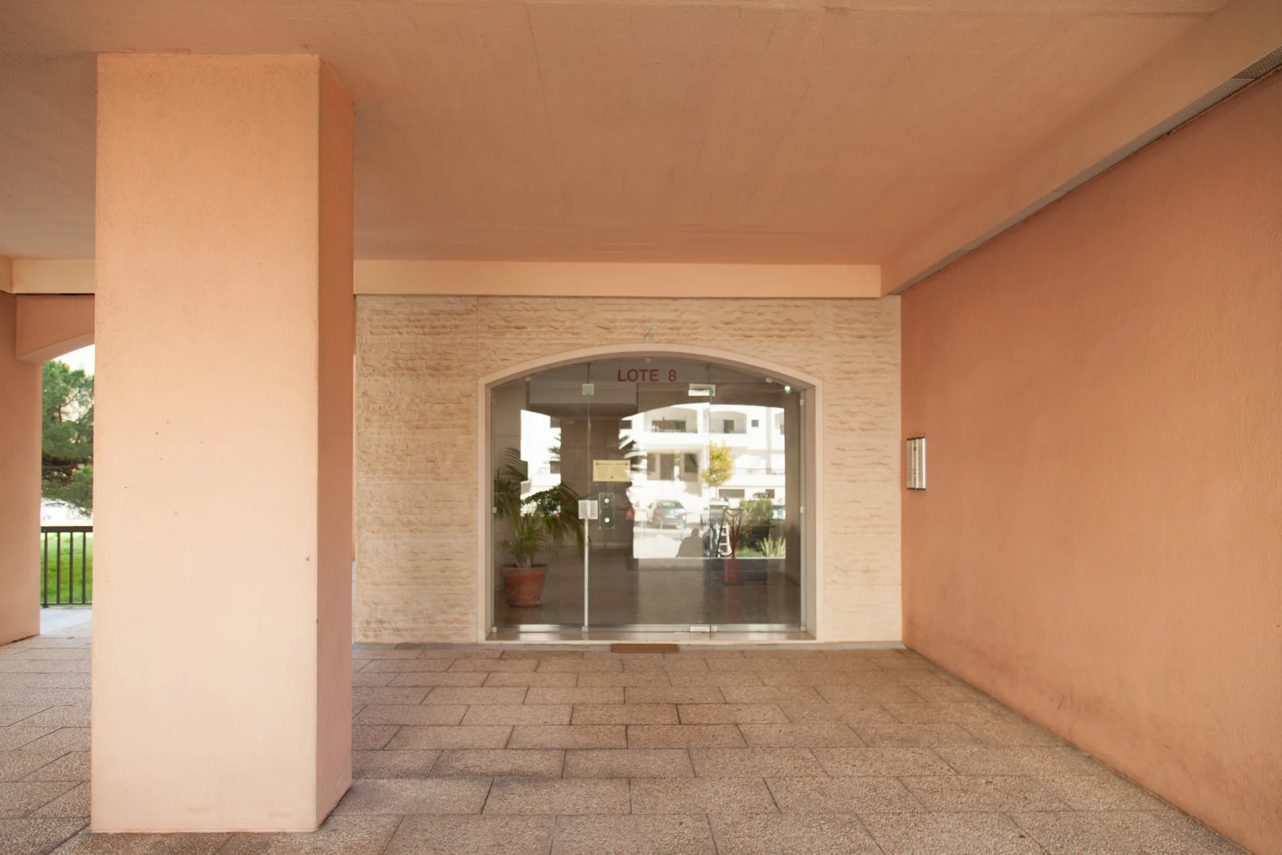 Una entrada cubierta con puertas de vidrio en una fachada de ladrillo.